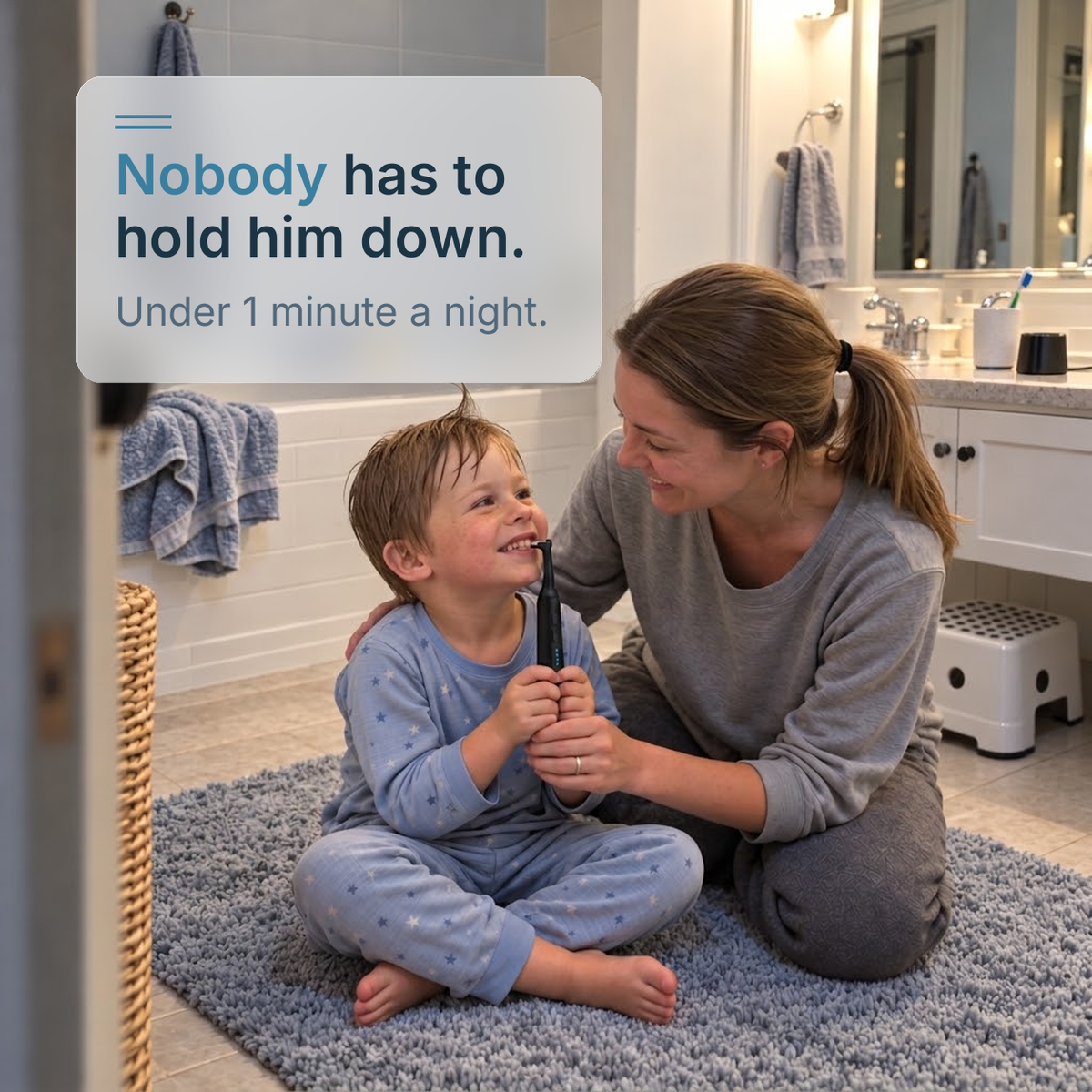 A toddler in pajamas holds the STRYN handle while his mom steers, at bedtime on the bathroom mat.